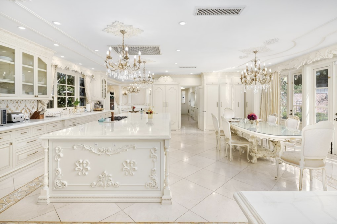 Bright cream colored kitchen with chandeliers
